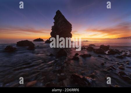 Wunderbare Landschaft von rauen Felsen in ruhigen Wasser des Meeres Auf dem Hintergrund des bunten Sonnenunterges in Island Stockfoto