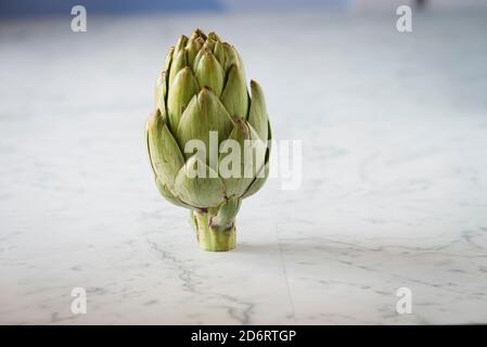 Frische Artischocke auf einer Marmor-Theke Stockfoto