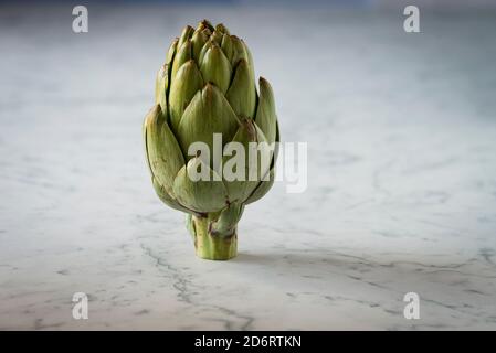 Frische Artischocke auf einer Marmor-Theke Stockfoto