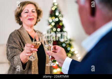 Entzückt reifen weiblichen Klappglas mit Champagner mit Ernte Freund Während wir Weihnachten zusammen feiern Stockfoto
