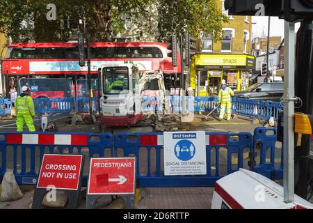 London, Großbritannien. Oktober 2020. Die Arbeiten an der unbeliebten Cycle Superhighway in Chiswick gehen weiter. CS9 ist eines der neuen Verkehrssysteme, die Empörung und Bestürzung unter Chiswick Bewohnern und denen verursachen, die die jetzt verengende High Road nutzen müssen. Arbeiter Entfernen der zentralen Schutzhütten, um Cycle Superhighway 9 unterzubringen. Kredit: Peter Hogan/Alamy Live Nachrichten Stockfoto