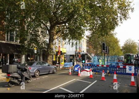 London, Großbritannien. Oktober 2020. Die Arbeiten an der unbeliebten Cycle Superhighway in Chiswick gehen weiter. CS9 ist eines der neuen Verkehrssysteme, die Empörung und Bestürzung unter Chiswick Bewohnern und denen verursachen, die die jetzt verengende High Road nutzen müssen. Arbeiter Entfernen der zentralen Schutzhütten, um Cycle Superhighway 9 unterzubringen. Kredit: Peter Hogan/Alamy Live Nachrichten Stockfoto