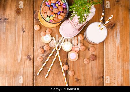 Niederländische Urlaubspostkarte Sinterklaas. Holzhintergrund mit Kinderschuh mit Karotten für Santa's Pferd, Pepernoten und Süßigkeiten. Blick von oben. Speicherplatz kopieren. Hochwertige Fotos Stockfoto