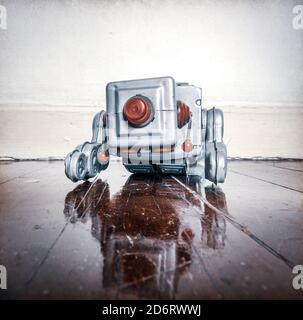 Über arbeitete retro Silber Roboter verdeckt auf alten Holzboden mit Reflexion Stockfoto