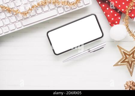 Mockup blank weißen Bildschirm Smartphone auf Home Office Schreibtisch Hintergrund für Weihnachten und Silvester-Party-Hintergrund-Konzept, Flat Lay Top-Ansicht mit Kopie s Stockfoto