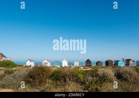 Eine Reihe von Strandhütten entlang der wilden Flora am Strand von Kingsdown, Deal, Kent, Großbritannien Stockfoto