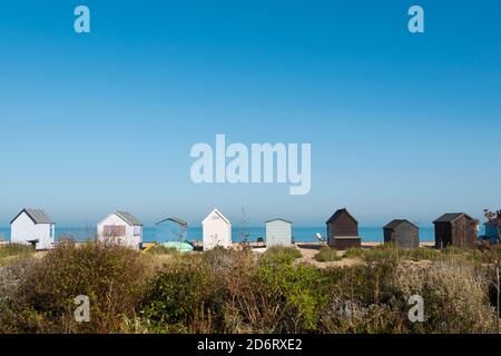 Eine Reihe von Strandhütten entlang der wilden Flora am Strand von Kingsdown, Deal, Kent, Großbritannien Stockfoto