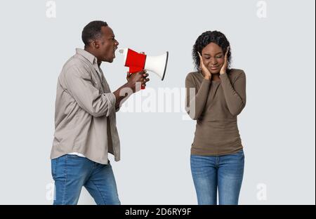 Wütend afrikanischen Kerl schreien durch Megaphon bei seiner Freundin Stockfoto