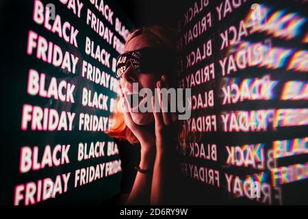 Nahaufnahme Porträt einer jungen Frau mit Sonnenbrille schreiend vor Überraschung Blick auf schwarzen freitag Verkaufsangebote Stockfoto
