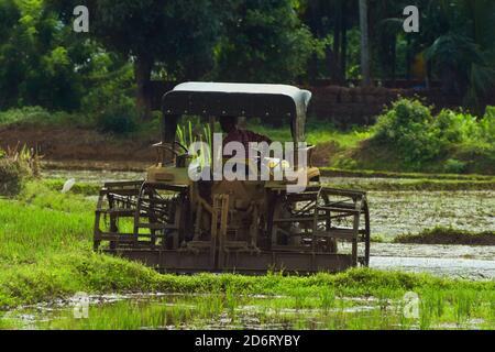 Pflügen eines landwirtschaftlichen Feldes mit einem Traktor in kerala Stockfoto