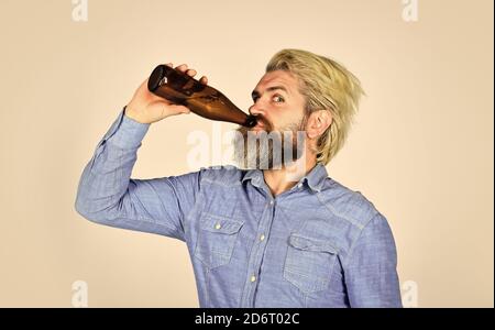 Reifer Mann hält Glasflasche Bier. Betrunkene Hipster männliche Handwerk Flaschenbier. Glücklicher Mann halten volle Glasflasche in der Hand. Männlich hält Flasche Bier. Hipster Rest in Pub. Sportliebhaber Kopf hoch. Stockfoto