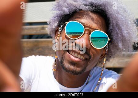 Schwarzer Mann mit afro Haar lächelnd und ein Selfie. Schwarzer Mann nimmt ein Selfie. Stockfoto