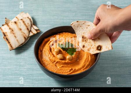 Kürbis Hummus in Schale auf blauem Hintergrund Stockfoto