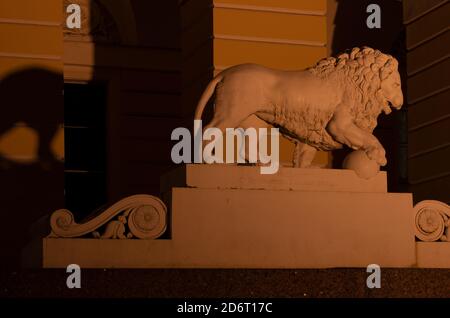 Sankt Petersburg, Russland - 17. November 2018: Nachtszene mit einer Statue eines ausscheidenden Löwen auf einem Sockel, der eine Pfote auf einem Ballon in der Nähe des Russen hält Stockfoto