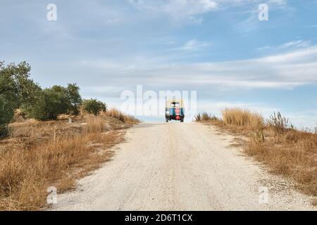 Einsames Auto, das im Sommer auf einer ländlichen Sandstraße fährt Hintergrund des blauen Himmels Stockfoto
