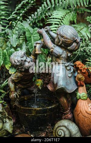 Thailand - 2019. Botanischer Garten Phuket. Skulptur von Kindern. Sie spielen mit dem Wasser, das aus dem Wasserhahn fließt. Stockfoto