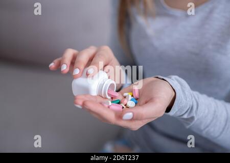 Selbstmordkonzept. Hoffnungslose junge Frau Gießen Handvoll Pillen aus Glas, Nahaufnahme Stockfoto