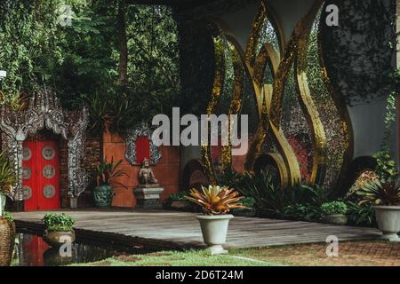Thailand - 2019. Botanischer Garten Phuket. Zentraler Eingang zum Botanischen Garten. Rote Tore mit silbernen Ornamenten und goldenen riesigen Seerosen eingerahmt. Stockfoto
