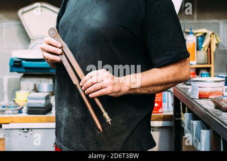 Crop unkenntlich Arbeiter mit Messwerkzeug in den Händen stehend in Modernes Servicezentrum Stockfoto