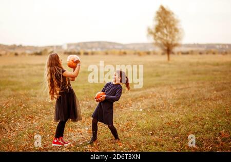 Zwei Mädchen im Teenageralter gehen im warmen Herbst an einer Waldstraße entlang. Stockfoto