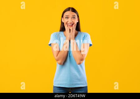 Beeindruckt Frau berühren ihr Gesicht Blick auf Kamera Stockfoto