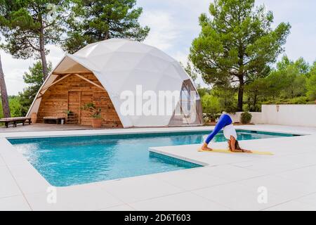 Seitenansicht einer anonymen schlanken Frau, die in Ardha Pincha steht Mayurasana Pose beim Yoga üben Stockfoto