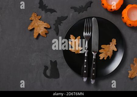 Halloween Tischdekor ist mit Kürbis förmigen Kerzen, Fledermäuse und Horror Party Dekor auf schwarzem Tisch dekoriert. Leerzeichen für Text. Draufsicht Stockfoto