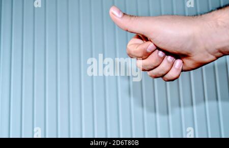 Hand und ihre Schatten und Reflexion auf der gemusterten Wand von OKAY Zeichen von Hand gemacht. Stockfoto