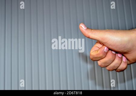 Hand und ihre Schatten und Reflexion auf der gemusterten Wand von OKAY Zeichen von Hand gemacht. Stockfoto