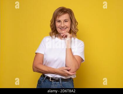 Selbstbewusst schöne reife Frau Blick auf Kamera und lächelnd Stockfoto