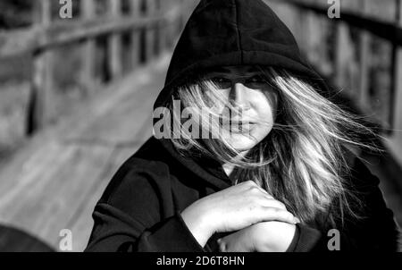 Porträt eines Teenagers in einem schwarzen Hoodie draußen. Stockfoto