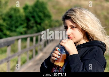 Porträt eines Teenagers in Sonnenbrille und einem schwarzen Hoodie draußen. Stockfoto