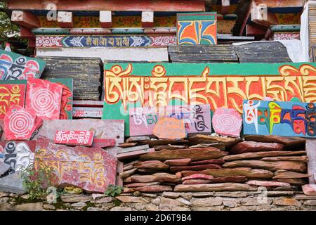 Sanskrit Mantra Om mani Padme Hum auf bunten alten, schäbigen Steinplatten bei Tageslicht Stockfoto