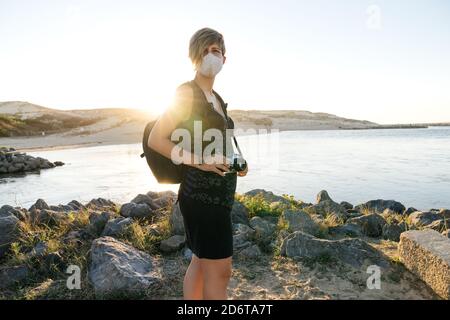 Die ganze Länge der positiv bärtigen älteren männlichen Reisenden, die während der Reise an einem sonnigen Tag in der Nähe eines modernen Anhängers stehen Stockfoto