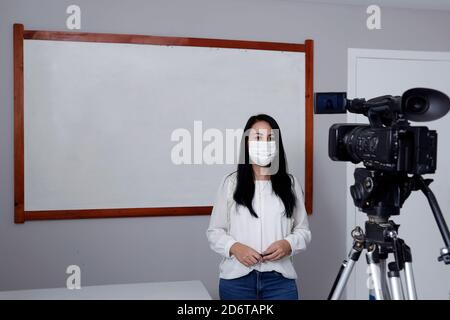 Lehrer mit Atemschutzmaske während der Präsentation von Online-virtuellen Klasse Stockfoto