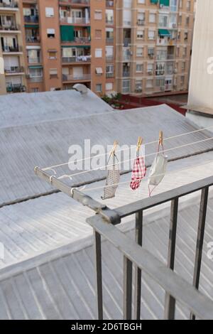 Von oben verschiedene gewaschene Gesichtsmasken, die auf der Wäsche hängen Seil auf Balkon im Stadtbezirk Stockfoto