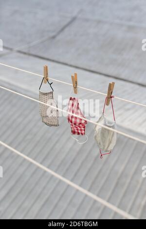 Von oben verschiedene gewaschene Gesichtsmasken, die auf der Wäsche hängen Seil auf Balkon im Stadtbezirk Stockfoto