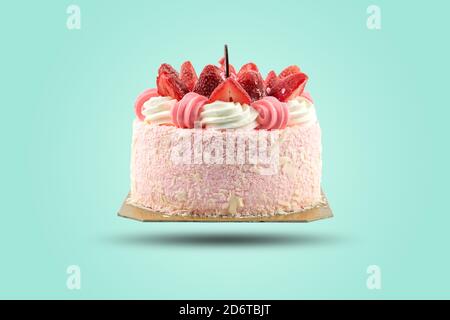 Nahaufnahme einer Geburtstagstorte mit Erdbeeren isoliert ein Pastellfarben Hintergrund gekrönt. Stockfoto