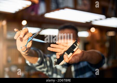 Männliche Barbier Hände halten professionelle Friseurwerkzeuge Stockfoto