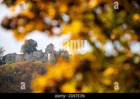 Bad Urach, Deutschland. Oktober 2020. Bunte Blätter hängen an einem Baum vor der Burgruine Hohenurach. Quelle: Sebastian Gollnow/dpa/Alamy Live News Stockfoto