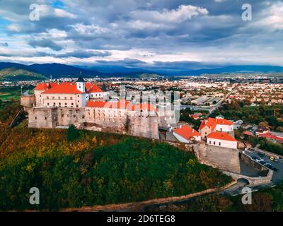 Luftaufnahme der mittelalterlichen Burg auf dem Berg in der kleinen europäischen Stadt im Herbst Saison. Schloss Palanok, Mukachevo, Ukraine Stockfoto