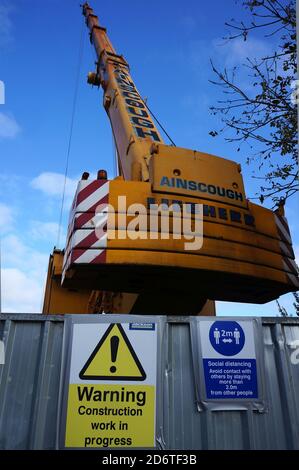 Ainscough Liebherr-Baukran arbeitet in der Nähe des Flussufers von Haven mit COVID 19-Warnschildern für soziale Distanzierung und Baustellen in BOSTON Lincol Stockfoto