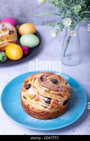 Craffin (Cruffin) mit Rosinen, Nüssen und kandierten Früchten. Osterbrot Kulich und bemalte Eier. Osterferien. Nahaufnahme. Stockfoto