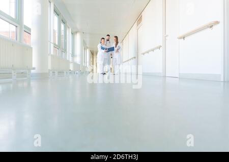 Drei Ärzte am Krankenhaus, Korridor mit kurzen Sitzung Stockfoto