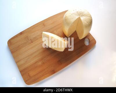 Milchkäse auf einem Holzbrett Nahaufnahme. Stockfoto