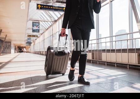 Mann, der seinen Koffer durch den Bahnhof trägt Stockfoto