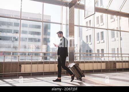 Mann, der das Smartphone benutzt, um das richtige Tor zu finden Stockfoto