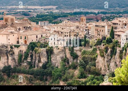 Landschaftlich schöner Blick auf die mittelalterliche Stadt Cuenca mit alten Steinhäusern Das Hotel liegt auf Hügeln mit grünen Bäumen unter blau bewölkt Himmel im Sommertag in Spanien Stockfoto