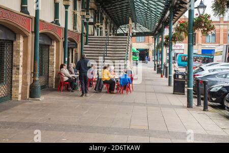 Die Leute saßen außerhalb der Markthalle in Darlington, England, Großbritannien und genossen eine Tasse Tee etc. Stockfoto