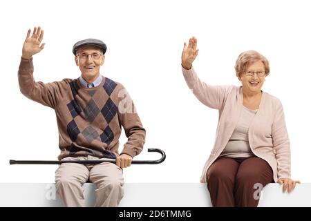 Ein älteres Paar sitzt auf einem leeren Schild und winkt An der Kamera isoliert auf weißem Hintergrund Stockfoto